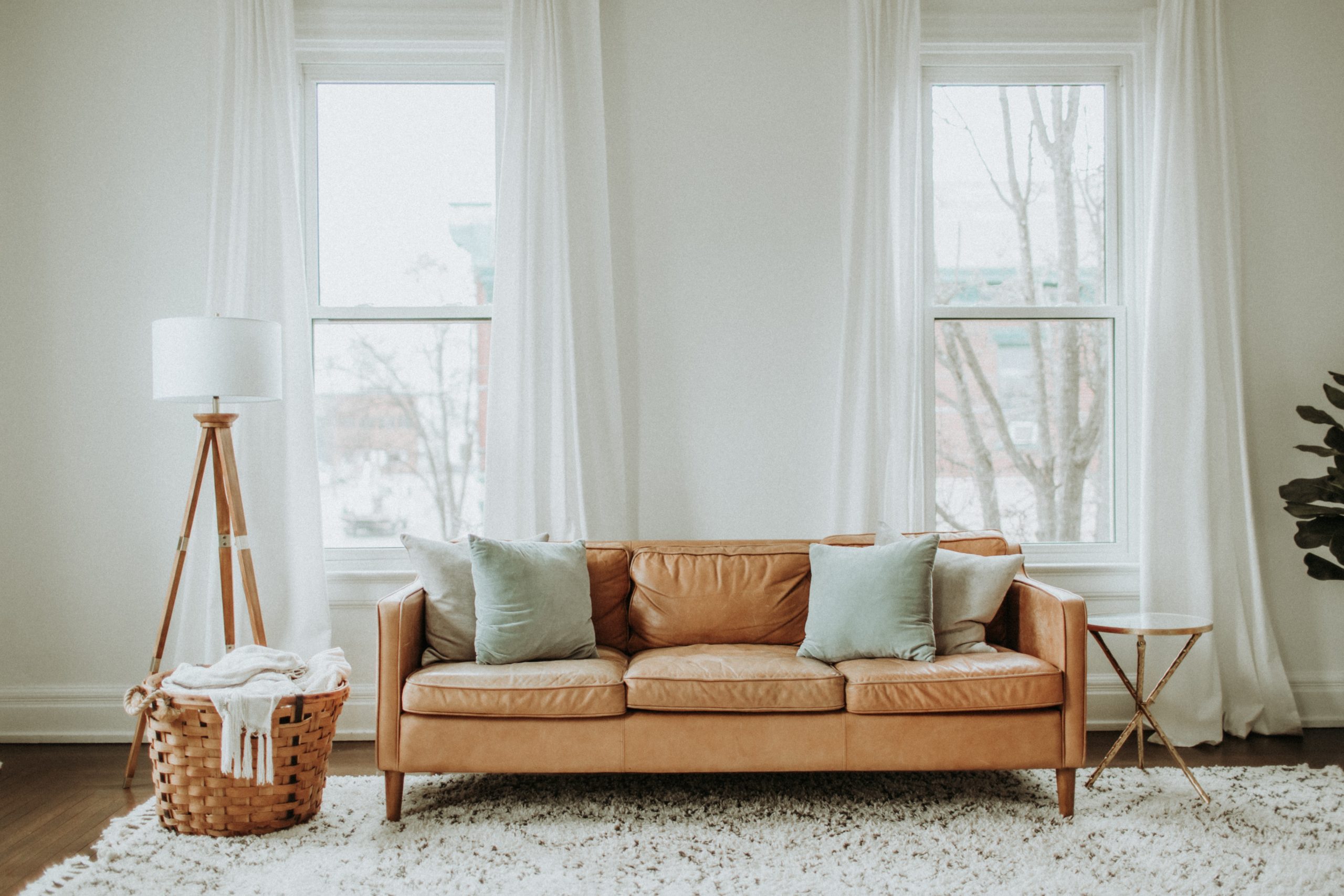 Couch in a living room with basket on the floor next to it